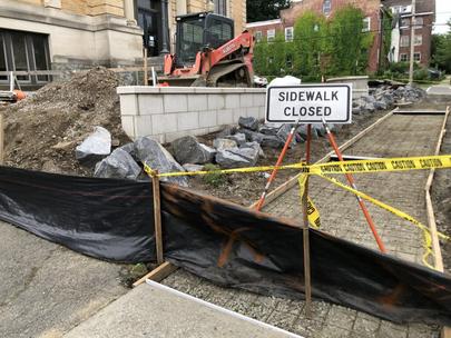 Sidewalk closed sign with sidewalk forms, tarp, and boulders