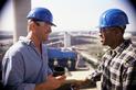 Workers talking to each other in hard hats on a constructino site