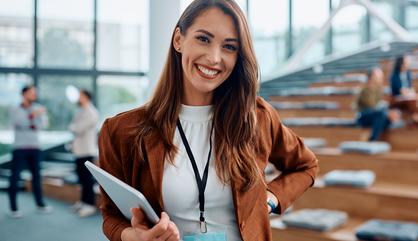 Image of a lady attending a meeting holding a laptop