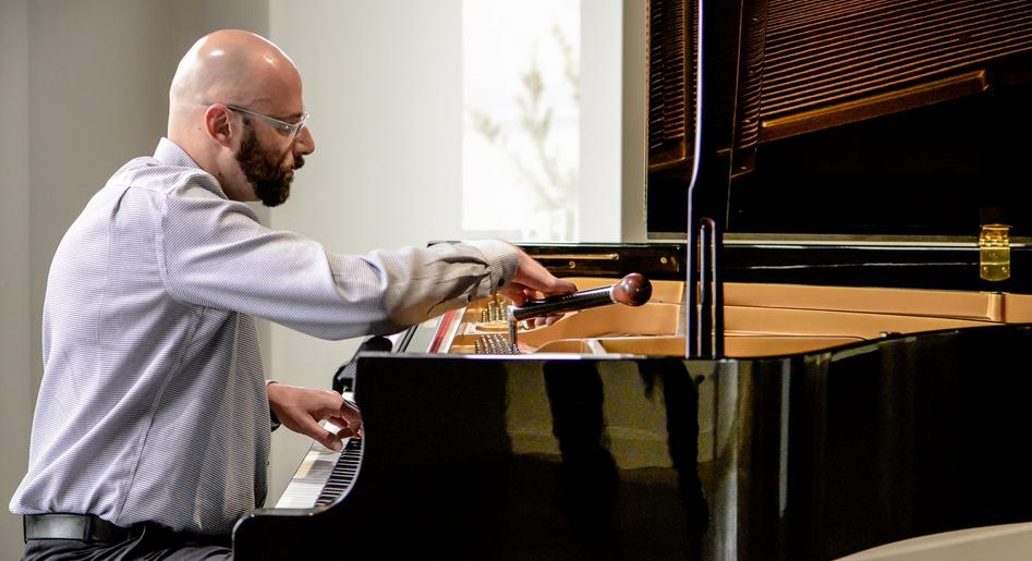 Joshua tunes and maintains a grand piano at an Edmonton venue.
