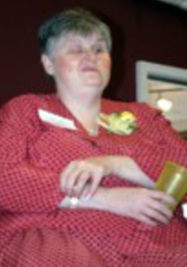 Becky, sitting on chair at at the 2004 STF reception, arm's folded, looking straight ahead.