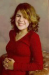 Senior picture of Gaby, hands together on waist, smiling looking at camera