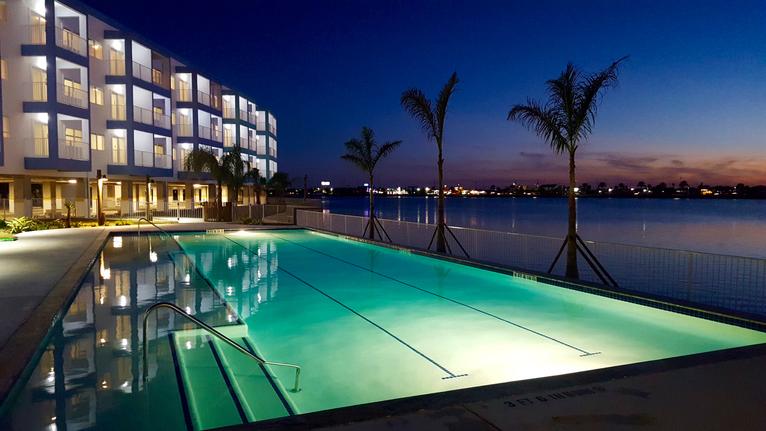Hotel poolside at dusk with lights and palm trees