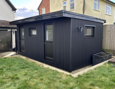 Garden office with black slatted cladding, 2 black doors and 2 small windows