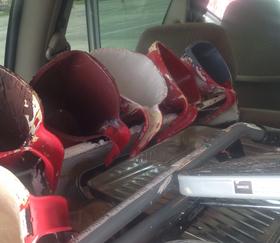 A set of six paint cups, each in a different color, sit in the back of a work van beside a step stool lying down and a standard size metal paint tray. Each cup is hooked over the lip of an 18" plastic paint tray to lay out to dry-- A scene after an especially industrious series of back-to-back custom paint jobs.