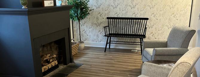 A fireplace, bench and easy chairs.