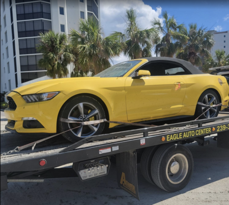 flooded yellow mustang car being picked up Fort Myers Beach