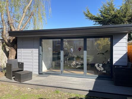 Modern grey slatted garden building with 3 panel bifold doors