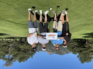 Optic Cup winning foursome Dr. Michelle Chaney, Mr. Patrick Roen, Dr. Michael Haas, & Mr. hoah Hummel standing on #2 tee box with mountains behind them.
