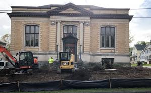 Library Building with cleared out lawn and excavation equipment.