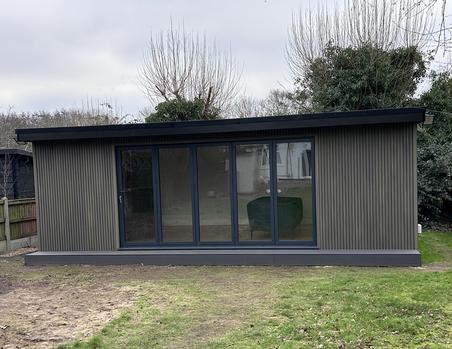 Garden room with beige slatted cladding and 5 panel bifold doors