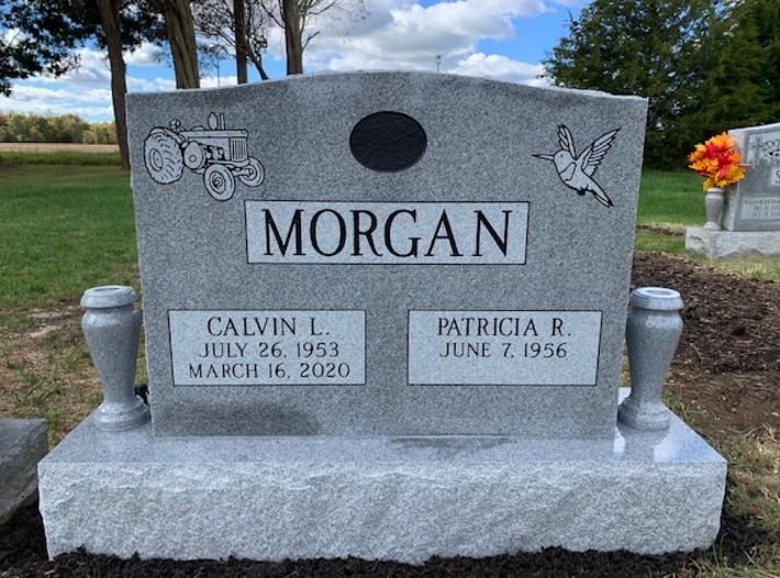headstone with tractor and hummingbird design