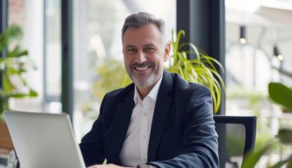 Image of an executive at an office desk working with a laptop