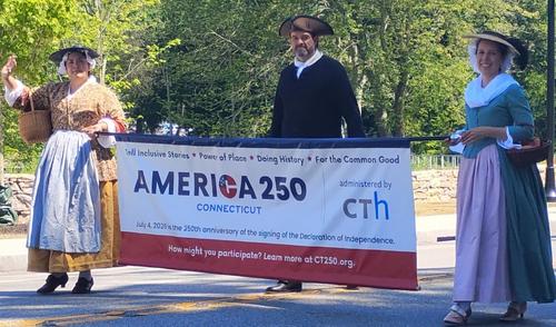 Dirty Blue Shirts march with America 250 banner.