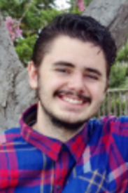 Outdoor picture of Philo smiling at camera.
