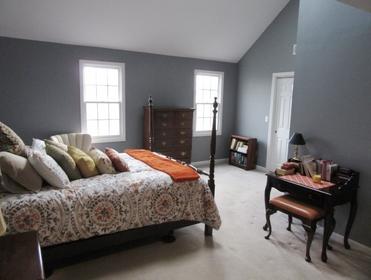 bedroom with high ceiling and wall painted gray.