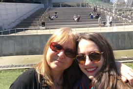 Two women one with arm over other smiling