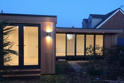 Large modern cedar clad garden room with French doors and 5 panel bifold doors