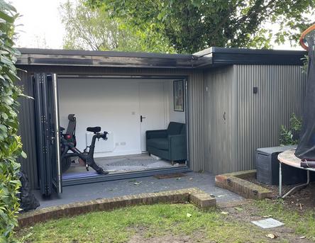 Garden office with integral shed, beige slatted cladding and open bifold doors