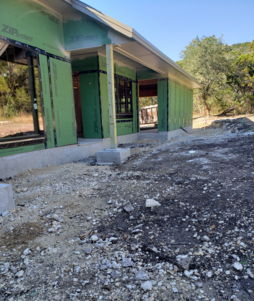 A landscaping job by wilson landscape in San Antonio texas of a circular rumblestone paver patio design with a beautiful stone fire pit in the middle and outdoor seating with river rock bordering
