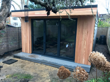 Modern cedar clad garden room with 3 panel bifold doors