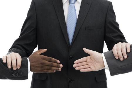 Man in suit facilitating the handshake of two men