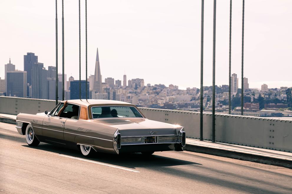 vintage car corssing bay bridge overlooking san francisco skyline landscape