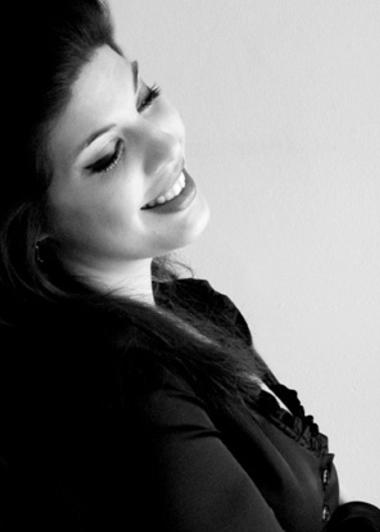 Black and white photo of spinto soprano Megn Marie Hart. She is seen from the right, her head slightly tilted back. Her eyes are closed, she is smiling.