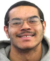 picture of Damien, with glasses on, smiling at camera.