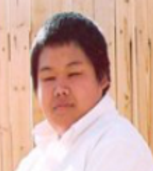 Deng facing to his right, looking back to his left at camera