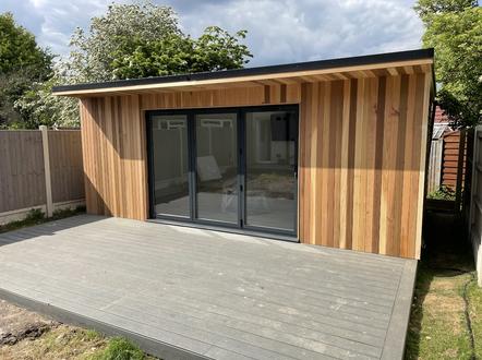 Modern cedar clad garden room with 3 panel bifold doors and integral shed