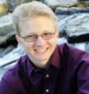 Outdoor picture of Byan, smiling, looking at camera.