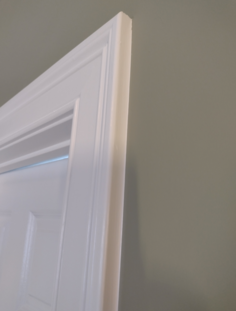 Owner and operator of JCB Painting cutting in a room.