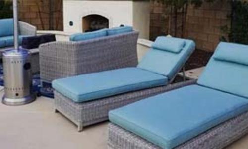 outoor lounge area with chimeney and outdoor furniture with light blue sunbrella cushions
