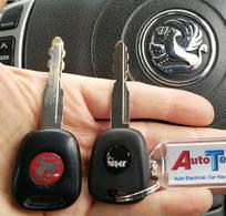 2 Vauxhall manual car keys side by side in front of a Vauxhall steering wheel