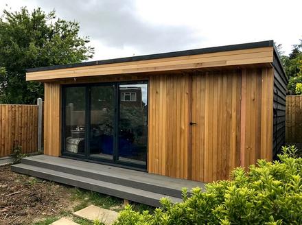 Modern cedar clad garden room with 3 panel bifold doors and integral shed