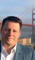 Picture of Kevin Brindley with view from Fort Point and Golden Gate Bridge behind him