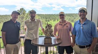 Team from Brown & Brow with the Optic Bear in the middle of their foursome.
