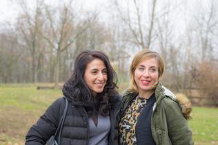 Two women arm in arm smiling