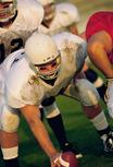 Highschool football players lined up getting ready to hike the ball