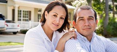 Loving couple in front of their home