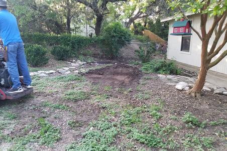 A landscaping job by wilson landscape in San Antonio texas of a circular rumblestone paver patio design with a beautiful stone fire pit in the middle and outdoor seating with river rock bordering