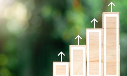 Stacked wooden blocks as a chart showing growth with a green background