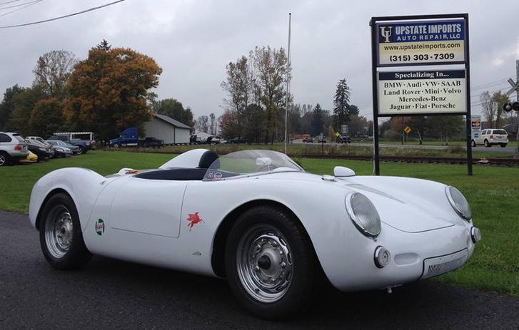 A classic white Porsche outside of Upstate Imports sign in Syracuse, NY