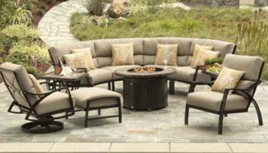 curved patio sectional with chairs and beige sunbrella cushions