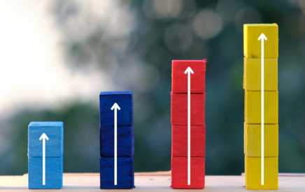 Stacked wooden cubes with arrows showing growth