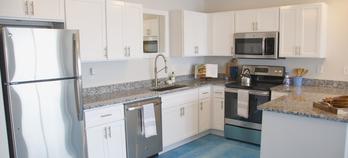 Modern kitchen with appliances and white cabinets.