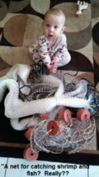 baby looking up holding a new seine net