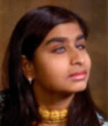 Semi-profile picture of Nadia, looking to her left with serious expression.