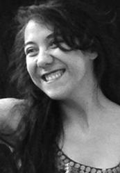 Portrait of Dora, smiling and looking to the left of the camera